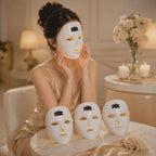 Woman wearing a white facial mask with three other masks on a table in a softly lit room.